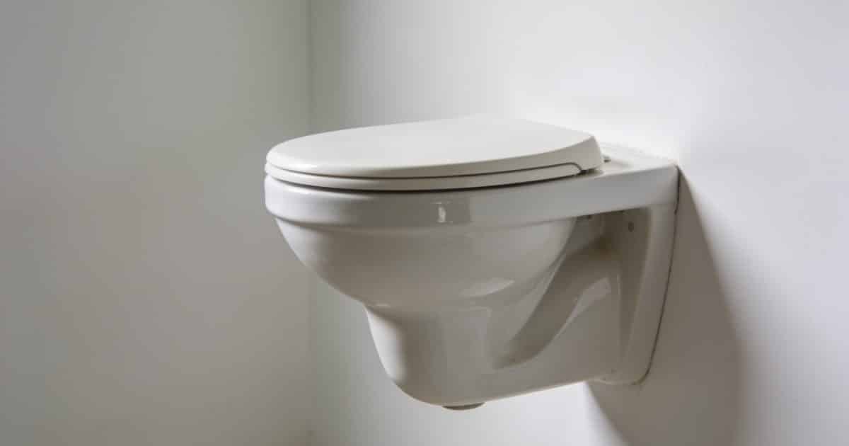Un WC suspendu à mi-hauteur sur un mur blanc.